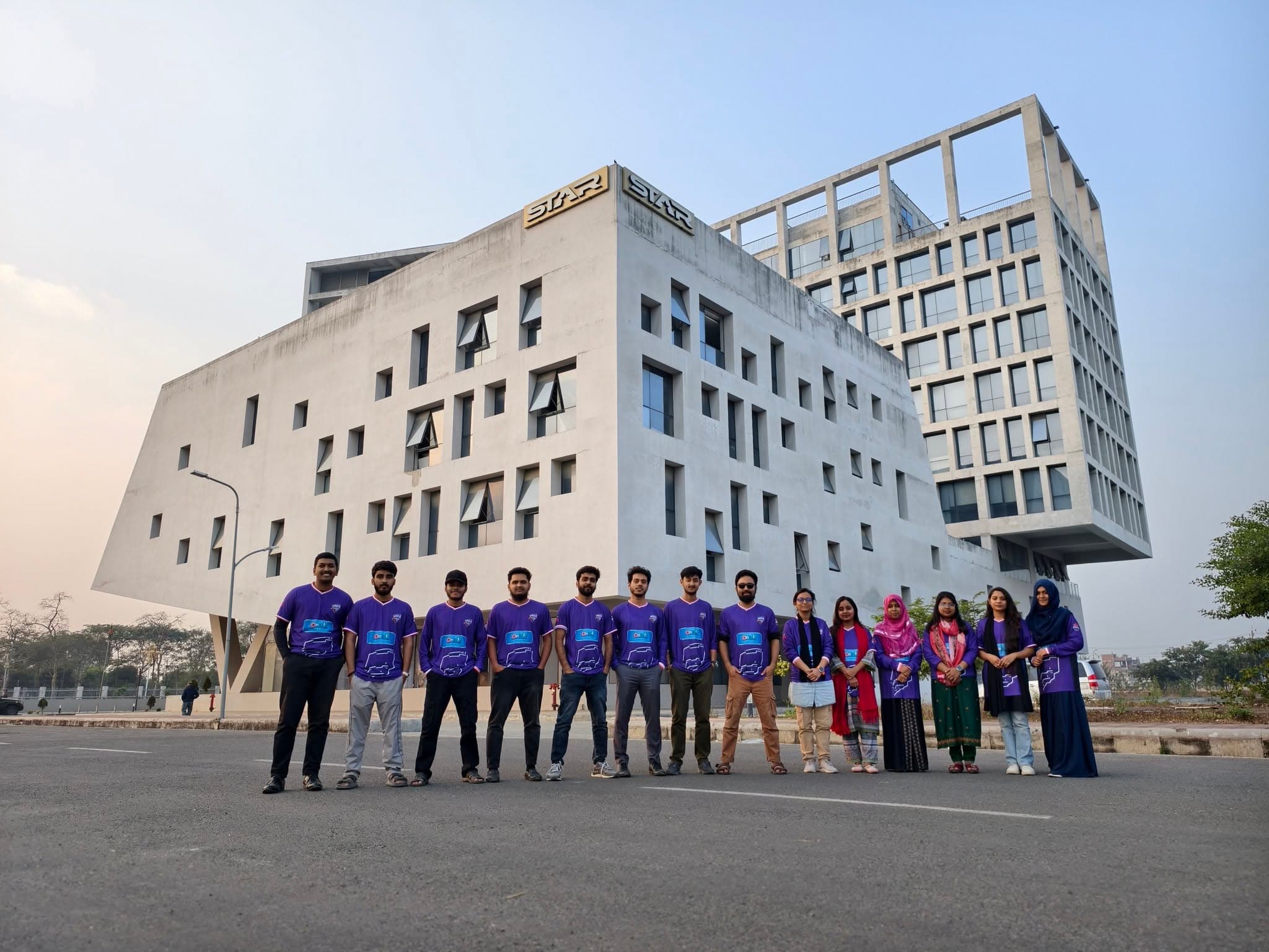 The team in front of the building at dusk